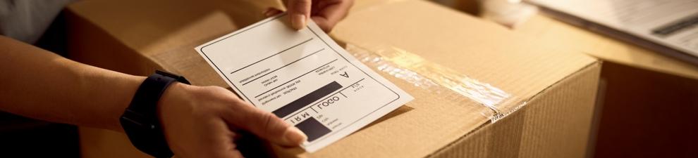 Person preparing a shipping label for a Priority Mail box.